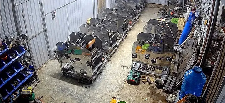 Um lote de máquinas em montagem, alinhadas na oficina