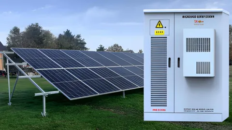 Conjunto de painéis solares ao lado de um galpão rural de processamento de caju, ligado às máquinas de corte e à iluminação